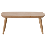 Miniature light wooden coffee table with a smooth, rounded top and tapered legs, adding a minimalist touch to any space.