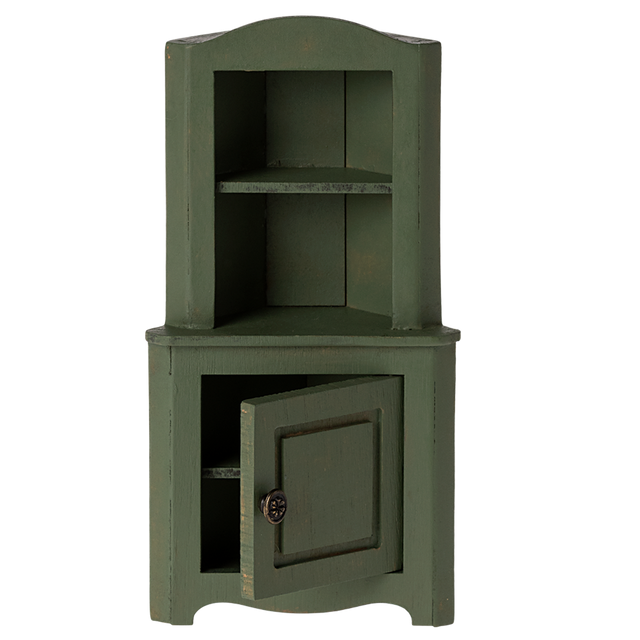 Green wooden corner miniature cabinet with an open lower door. It features two shelves above and a decorative knob. The piece conveys a rustic, vintage charm.