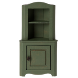 Green wooden corner miniature cabinet with an open top shelf and a bottom cupboard featuring a round metal knob. The rustic design evokes a vintage, cozy charm.