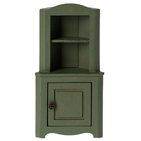 Green wooden corner miniature cabinet with an open top shelf and a bottom cupboard featuring a round metal knob. The rustic design evokes a vintage, cozy charm.