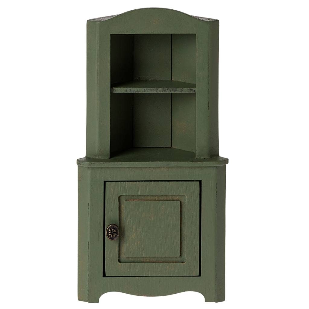 Green wooden corner miniature cabinet with an open top shelf and a bottom cupboard featuring a round metal knob. The rustic design evokes a vintage, cozy charm.