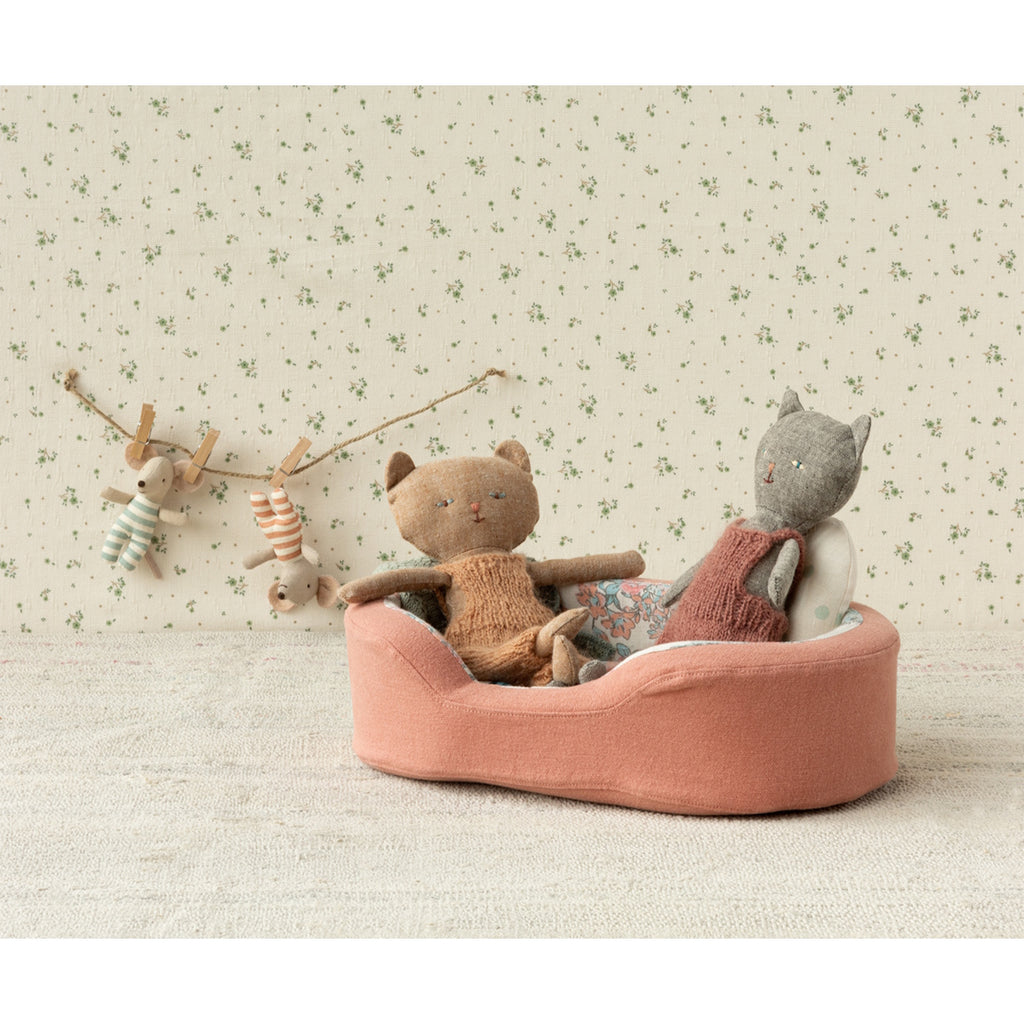 The image shows a soft toy dogs bed in coral, with a pillow and blanket on a white background.