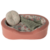 The image shows a soft toy dogs bed in coral, with a pillow and blanket on a white background.