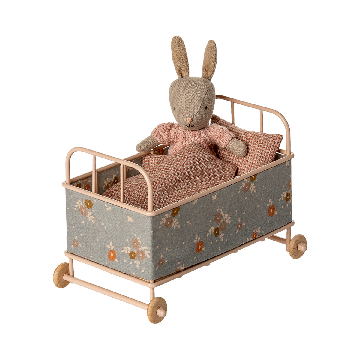 Vintage-style miniature toy crib with floral fabric, soft brown and beige tones. Features small wheels, a houndstooth pillow, and a cozy blanket, evoking a nostalgic charm.