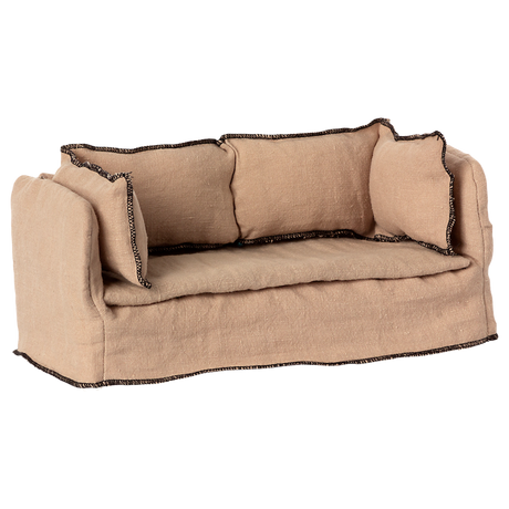 Beige fabric dollhouse sofa with three cushioned backrests, trimmed in dark stitching. The cozy design suggests a miniature living room setting.