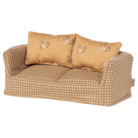 A vintage-style miniature sofa with a beige and brown checkered pattern. It features two floral-patterned cushions, conveying a cozy and nostalgic vibe.