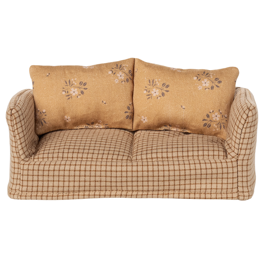 A vintage-style miniature sofa with a beige and brown checkered pattern. It features two floral-patterned cushions, conveying a cozy and nostalgic vibe.