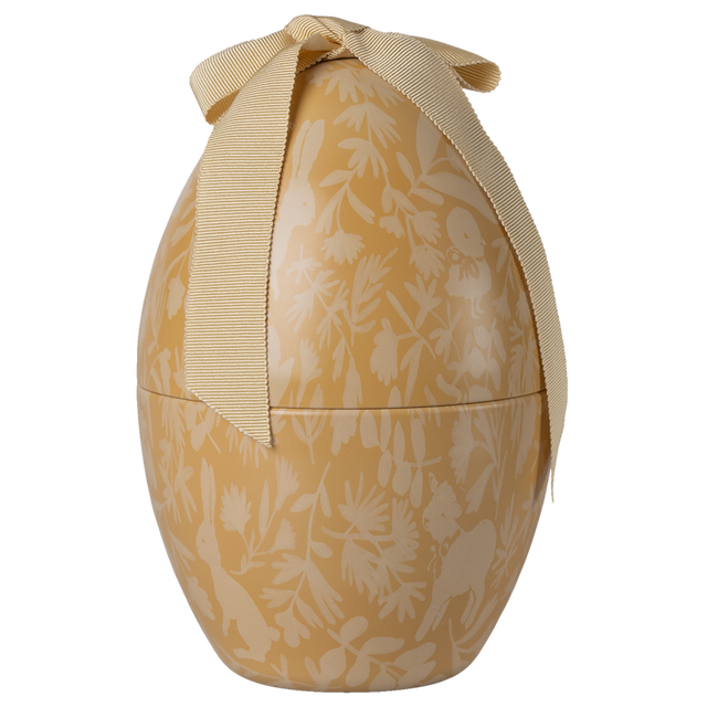 A decorated golden egg-shaped box with a cream floral pattern and animals, topped with a large cream ribbon bow, set against a white background.