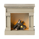 Miniature off-white dollhouse fireplace with realistic glowing logs inside.