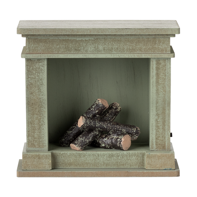 A decorative miniature fireplace with a greenish-gray finish, holding several stacked logs inside, showcasing a cozy and rustic vibe.