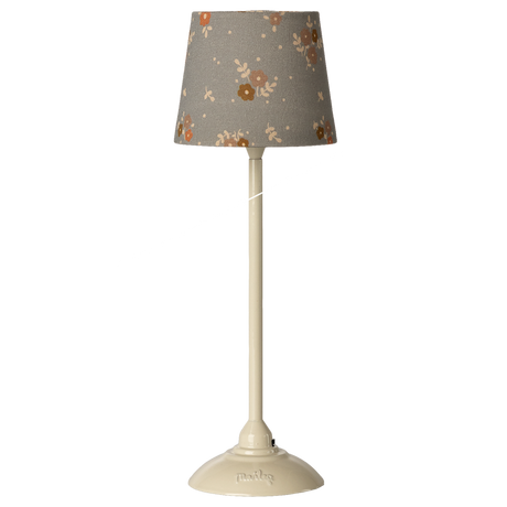 A tall ivory lamp with a gray floral-patterned shade stands against a white background. The lamp has a sleek design, exuding a modern vintage elegance.