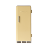 A toy refrigerator in a pale yellow color, is shown with its door slightly ajar. The fridge has a retro design with rounded edges, a silver-colored handle on the right side of the door, and the word "MAILEG" embossed vertically on the door. Inside, three shelves with ribbed textures are visible.