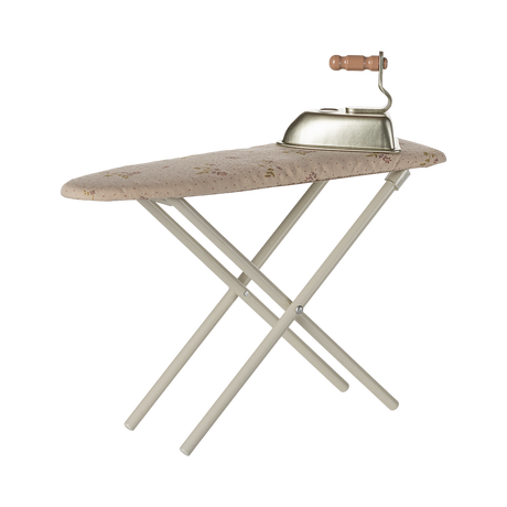 A miniature, foldable ironing board with a floral-patterned surface and a vintage-style iron featuring a wooden handle, set against a plain background.