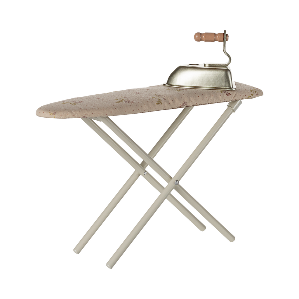 A miniature, foldable ironing board with a floral-patterned surface and a vintage-style iron featuring a wooden handle, set against a plain background.