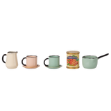 A row of miniature vintage kitchenware: cream pitcher, pink cup with saucer, green cup with saucer, can of tomatoes, and a green saucepan with a handle. Retro vibe.