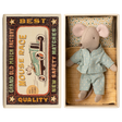 Toy mouse in blue pajamas lies in a matchbox, resembling a cozy bed. The box has vintage-style "Mouse Race" label. Cute and nostalgic.