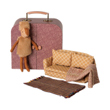 Maileg little sister reindeer doll with a miniature patterned suitcase wardrobe, couch, and rug.
