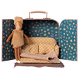 Maileg little sister reindeer plush doll inside a toy suitcase dollhouse with a miniature sofa.