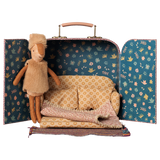 Maileg little sister reindeer plush doll inside a toy suitcase dollhouse with a miniature sofa.