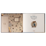 Open book spread. Left page shows a whimsical desert wallpaper with cacti, horses, and a framed note. Right page reads "Louimax Dreams of Being an Adult" with an illustration of a mouse on a scooter. Tone is playful and imaginative.
