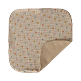 A soft, beige baby blanket with colorful polka dots in orange, green, and yellow. It has rounded corners and a plush backside, creating a cozy feel.