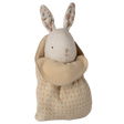 A plush toy rabbit with floral-patterned ears and an embroidered face is snugly swaddled in a soft, polka-dotted beige blanket, set against a white background.