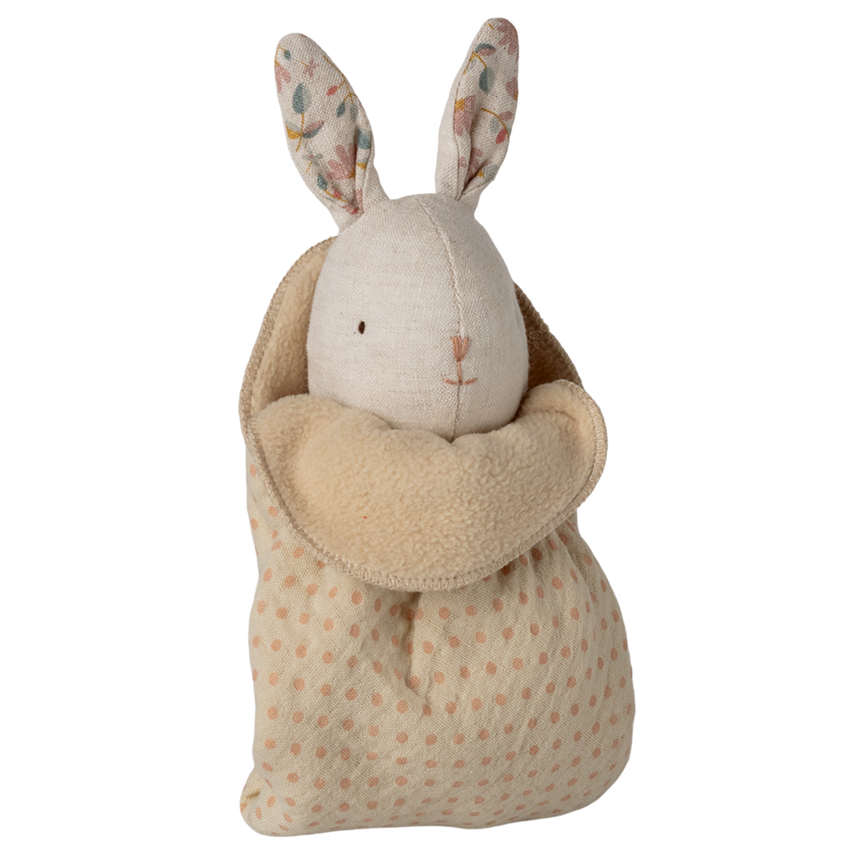 A plush toy rabbit with floral-patterned ears and an embroidered face is snugly swaddled in a soft, polka-dotted beige blanket, set against a white background.