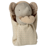 A plush elephant toy with a soft beige body and patterned ears is cozy in a polka-dotted blanket, conveying warmth and comfort against a white background.