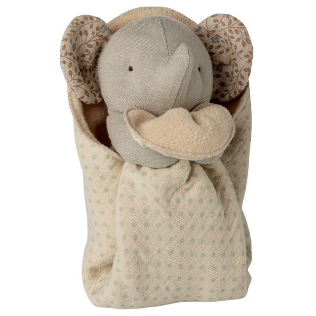 A plush elephant toy with a soft beige body and patterned ears is cozy in a polka-dotted blanket, conveying warmth and comfort against a white background.