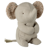 A beige fabric elephant toy with stitched eyes sits against a white background. Its large ears have a leaf pattern, creating a soft and cozy feel.