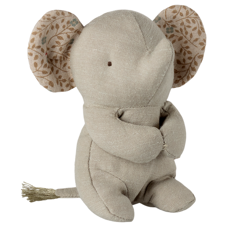 A beige fabric elephant toy with stitched eyes sits against a white background. Its large ears have a leaf pattern, creating a soft and cozy feel.