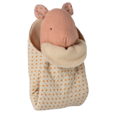 A soft pink fabric mouse peeks out of a cozy, polka-dotted sleeping bag with an orange and cream color scheme on a white background.
