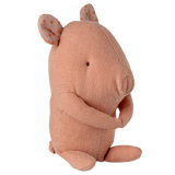 A soft, peach-colored fabric pig toy with small eyes and floppy ears featuring orange polka dots, sitting against a white background.