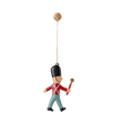 Toy soldier ornament hanging by a string. The soldier wears a black hat, red coat, and blue pants, holding a red baton. Simple, playful design.