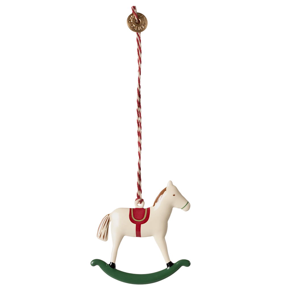A cream-colored rocking horse ornament hangs from a striped cord.