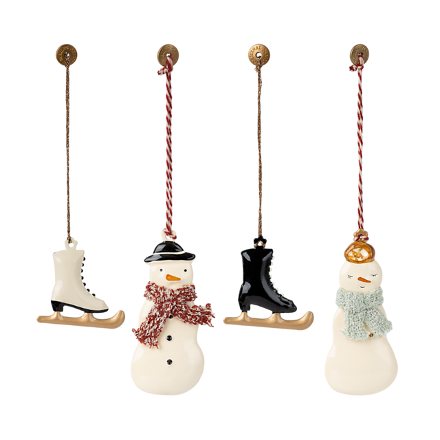 Three charming holiday ornaments: a snowman with a red scarf, an ice skate, and a snowwoman wearing a green scarf, all hanging.
