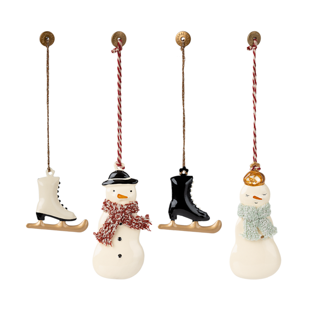 Three charming holiday ornaments: a snowman with a red scarf, an ice skate, and a snowwoman wearing a green scarf, all hanging.