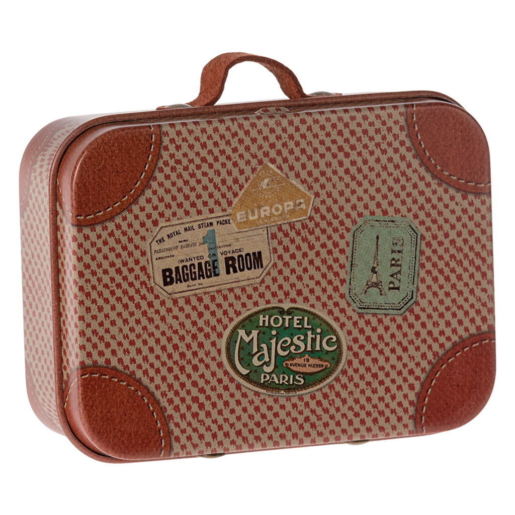 Vintage suitcase with a red and beige pattern, adorned with travel stickers including "Baggage Room," "Hotel Majestic," and the Eiffel Tower. Retro travel vibe.