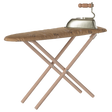 A vintage-style toy ironing board with a patterned, brown cover, and a small metal toy iron with a wooden handle sits on top. The background is white.