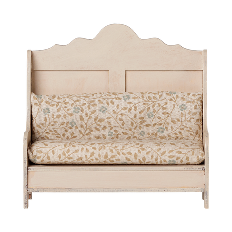 Maileg dollhouse miniature wooden kitchen bench in light sand with a floral patterned cushion.
