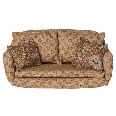 Maileg miniature dollhouse sofa bed in ocher with floral patterned pillows.