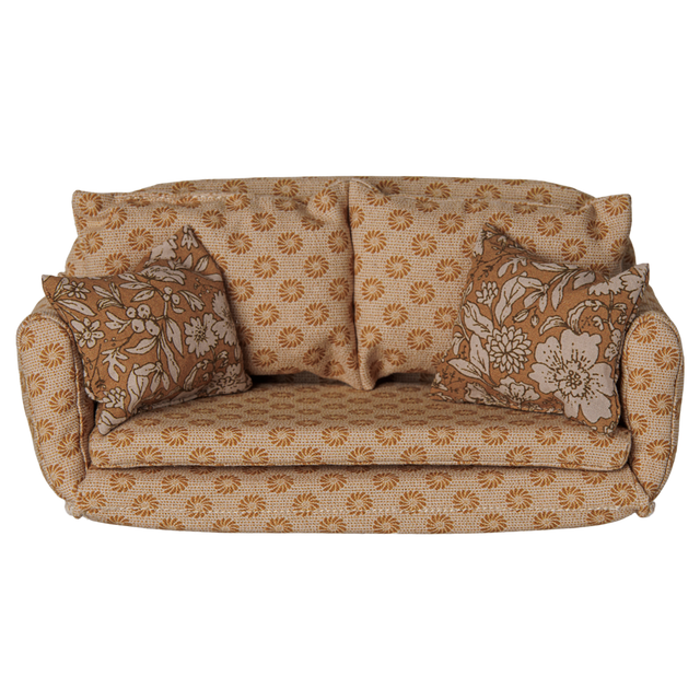 Maileg miniature dollhouse sofa bed in ocher with floral patterned pillows.