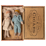 Two toy mice in pajamas rest in a cigar box, one in a polka-dot gown and mask, the other in blue stripes. The mood is cozy and nostalgic.