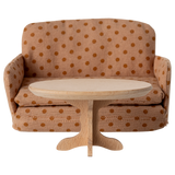 A miniature, oval wooden table with a smooth top and a decorative, carved pedestal base, showcasing a natural wood finish.