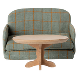 A miniature, oval wooden table with a smooth top and a decorative, carved pedestal base, showcasing a natural wood finish.
