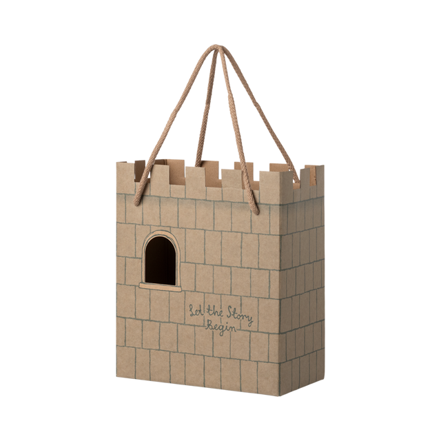 Cardboard gift bag shaped like a castle with a crenelated top. It features a cutout window and the words "Let the Story Begin" printed on it.