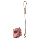 Pink quilted dog harness with a patterned leash featuring floral designs, set against a white background. The design is playful and stylish.