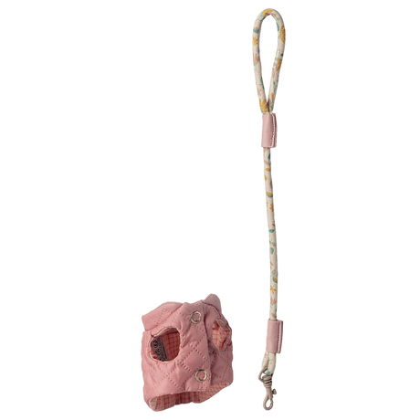 Pink quilted dog harness with a patterned leash featuring floral designs, set against a white background. The design is playful and stylish.