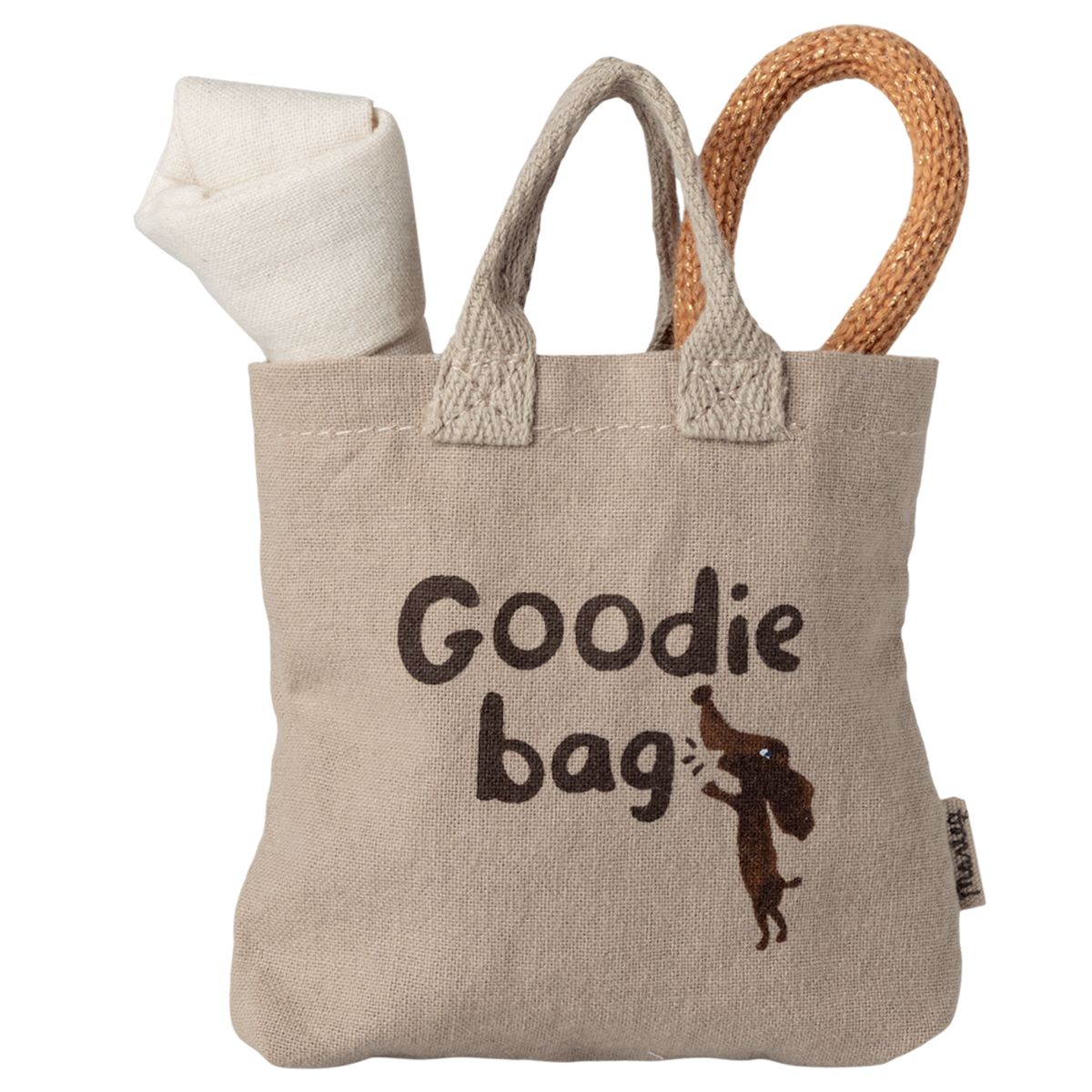 Beige fabric bag with "Goodie bag" text and dog graphic. Rolls of white and brown fabric peek out, creating a playful, cozy feel.