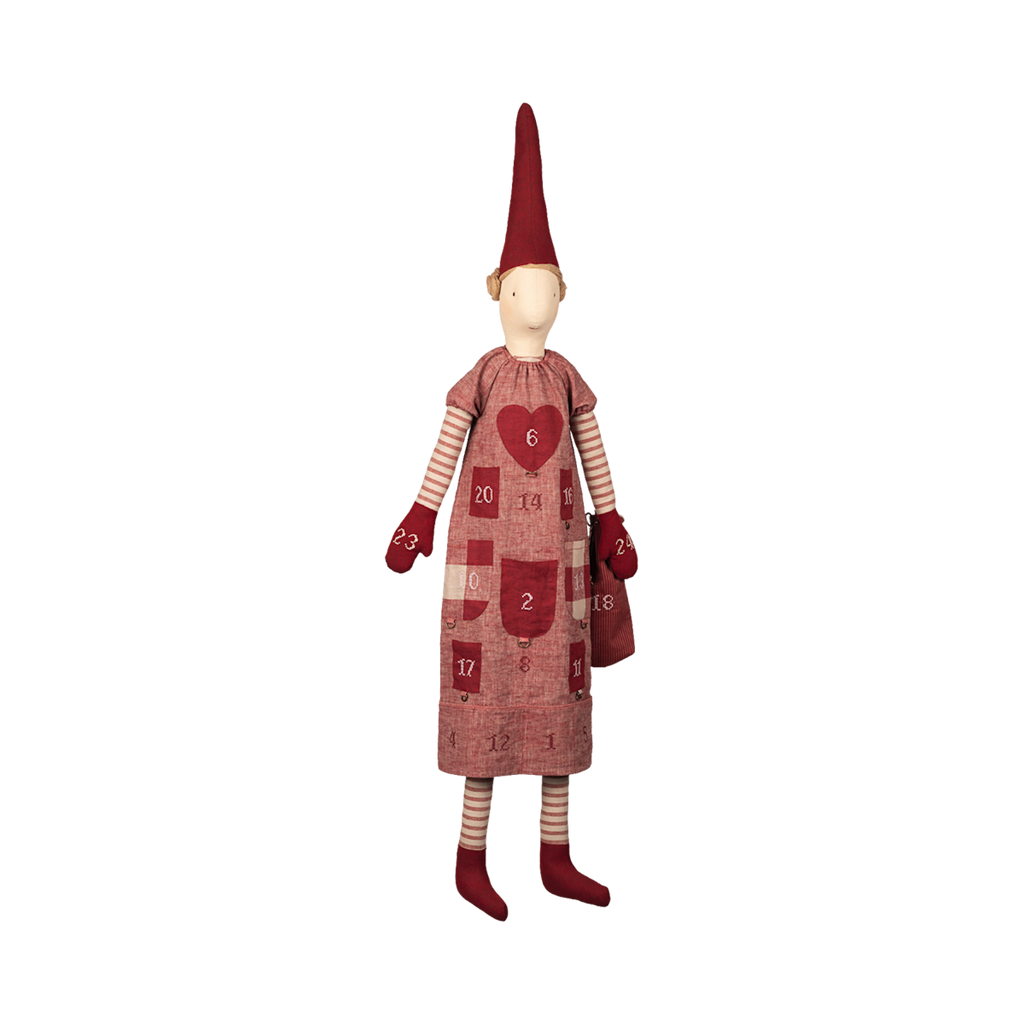 A whimsical doll with a tall red hat and striped leggings wears an advent calendar dress with numbered pockets and a heart design, creating a festive, joyful tone.